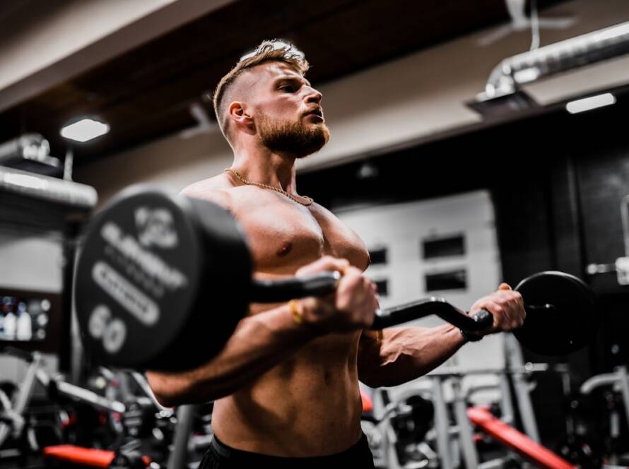 Persona realizando la fase excéntrica de un ejercicio de fuerza con mancuerna en el gimnasio