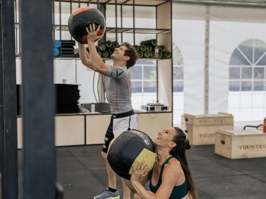 Dos personas entrenando con balones medicinales: el entrenamiento funcional lidera las tendencias fitness en España 2026