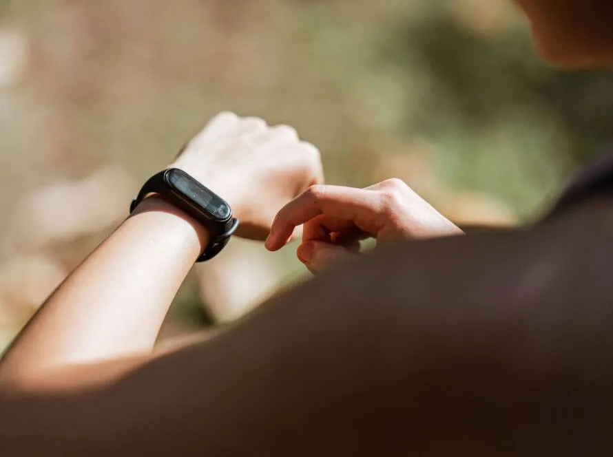 Persona consultando su pulsera de actividad durante un entrenamiento: los wearables fitness dominan 2026