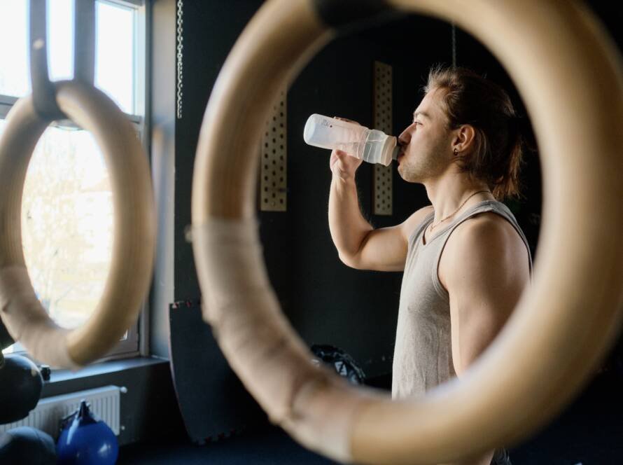 Deportista bebiendo agua durante un entrenamiento de alta intensidad, contexto de suplementación con bicarbonato de sodio