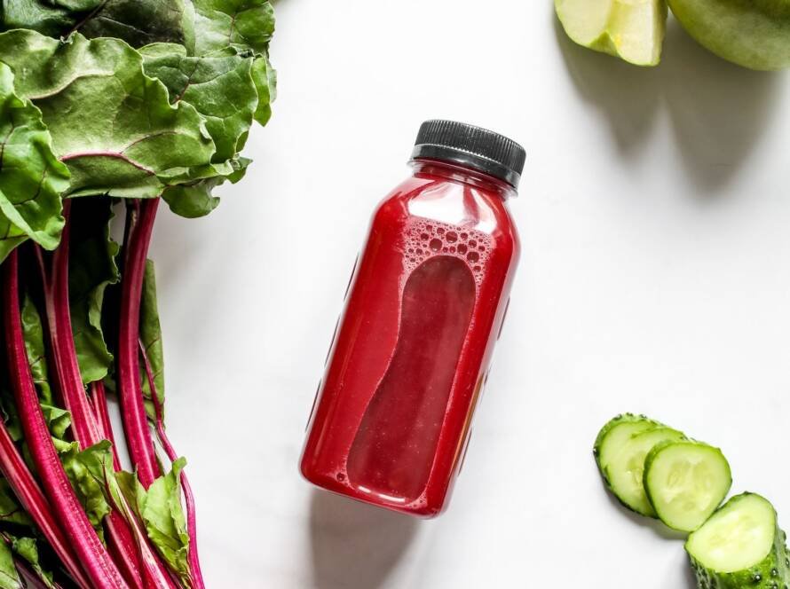 Remolacha fresca junto a una botella de zumo de remolacha, manzana y pepino, ingredientes ricos en nitratos para el rendimiento deportivo